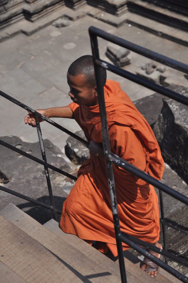 Kambodža - Mních stúpajúci po schodoch v chráme Angkor Wat