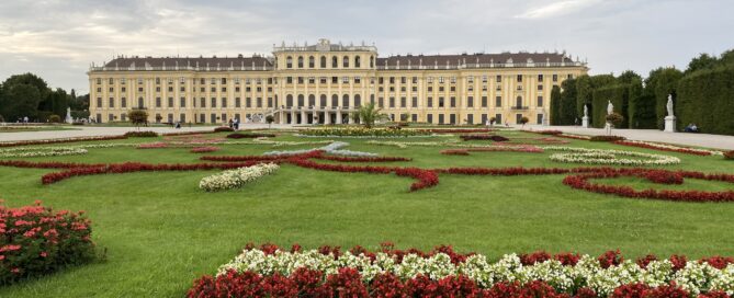 Palác Schönbrunn: pohľad na kvetiny v popredí a vzadu široká stavba paláca
