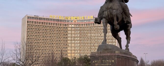 Taškent - socha Amira Timura v pozadí Hotel Uzbekistan