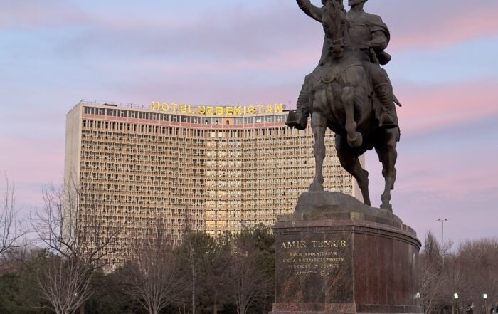 Taškent - socha Amira Timura v pozadí Hotel Uzbekistan